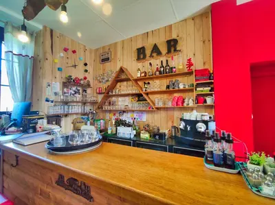 a bar in a restaurant with wooden walls and a counter at Le sapin rouge - Restaurant - bar - chambres d'hôtes in Artigues