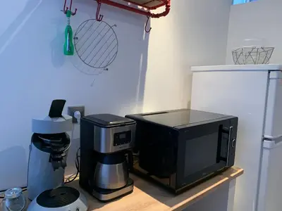 a kitchen with a coffee maker and a microwave at La Roche - Studio 2 étoiles Eco Responsable avec Tv Connectée in Maury