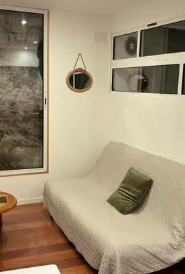 a bed with a green pillow in a room at La Roche - Studio 2 étoiles Eco Responsable avec Tv Connectée in Maury