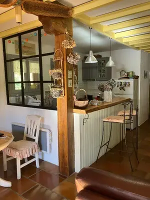 a kitchen with a counter and chairs in a room at Chalet de charme in Montfort-sur-Boulzane