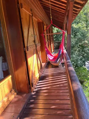 a hammock hanging on the porch of a cabin at Chalet de charme in Montfort-sur-Boulzane