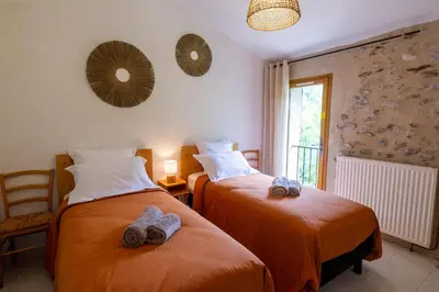 two beds in a room with towels on them at La Mazette, les pieds dans l'eau ! Privatisée ! 16 Pers in Olargues