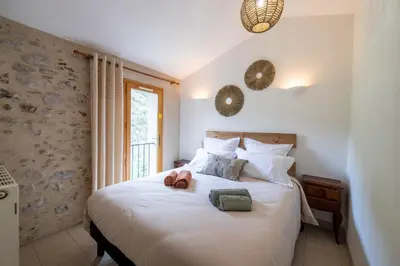 a bedroom with a bed with two slippers on it at La Mazette, les pieds dans l'eau ! Privatisée ! 16 Pers in Olargues