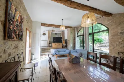 a kitchen and living room with a large wooden table at La Mazette, les pieds dans l'eau ! Privatisée ! 16 Pers in Olargues