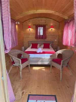 a bedroom with a bed and two chairs in a cabin at Camping La Capelle in Saint-Martin-Lalande