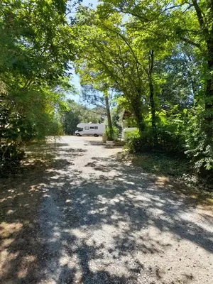 an empty road with a camper parked on the side at Camping La Capelle in Saint-Martin-Lalande