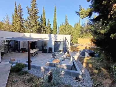 a patio with a couch and an umbrella at Magnifique villa avec piscine, jacuzzi et billard in Limoux