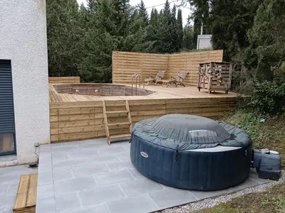 a backyard with a hot tub and a wooden deck at Magnifique villa avec piscine, jacuzzi et billard in Limoux