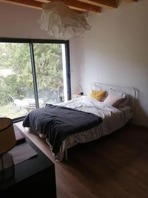 a bedroom with a bed with a large window at Magnifique villa avec piscine, jacuzzi et billard in Limoux
