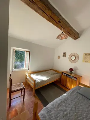 a bedroom with a bed and a window at appartement chez l'artiste in Minerve