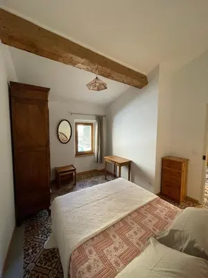 a bedroom with a large bed and a window at appartement chez l'artiste in Minerve