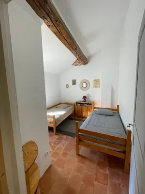 a bedroom with two beds in a attic at appartement chez l'artiste in Minerve