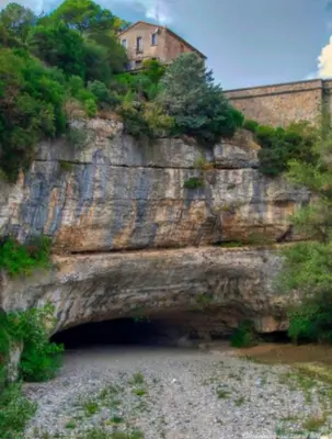 a building sitting on top of a rock mountain at appartement chez l'artiste in Minerve