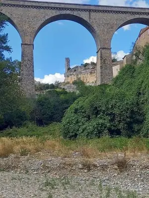 a bridge with two arches on top of a hill at appartement chez l'artiste in Minerve