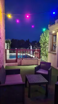 a patio with two benches and a playground at night at Gîte avec Piscine Proche de Carcassonne in Couffoulens