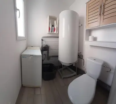 a white bathroom with a toilet and a sink at Gîte avec Piscine Proche de Carcassonne in Couffoulens