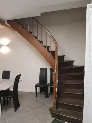 a room with a staircase with two chairs and a table at Gîte avec Piscine Proche de Carcassonne in Couffoulens