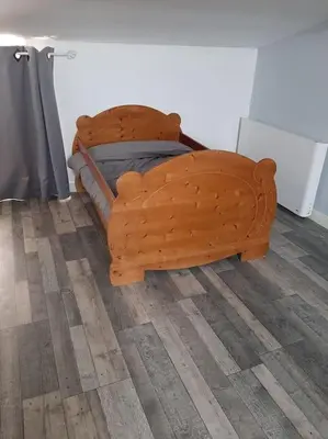 a wooden bed sitting on top of a wooden floor at Gîte avec Piscine Proche de Carcassonne in Couffoulens