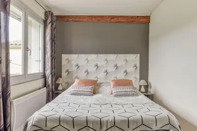 a bedroom with a bed with a padded headboard and a window at Gîte - Holiday Home Vent Autan in Limoux