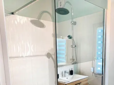 a bathroom with a shower and a sink and a mirror at L'alcôve - T2 Calme, Terrasse & Parking privé in Castres