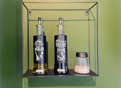 a shelf with two bottles of alcohol and a candle at L'alcôve - T2 Calme, Terrasse & Parking privé in Castres