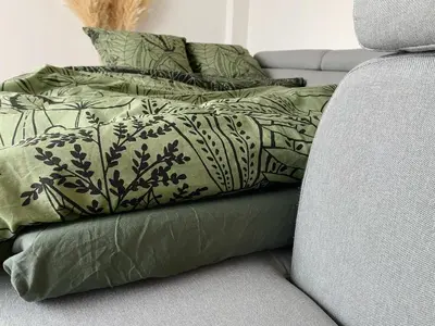 a couch with green pillows on top of it at L'alcôve - T2 Calme, Terrasse & Parking privé in Castres