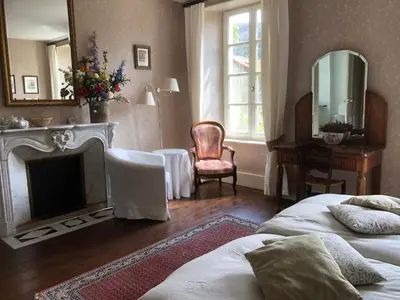 a bedroom with two beds and a fireplace and a mirror at La Cerisaie - Chambres d'hôtes & gites in Riols