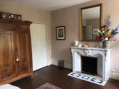 a living room with a fireplace and a mirror at La Cerisaie - Chambres d'hôtes & gites in Riols