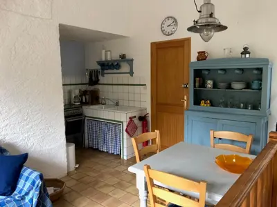 a kitchen with a table and a blue cabinet at La Cerisaie - Chambres d'hôtes & gites in Riols