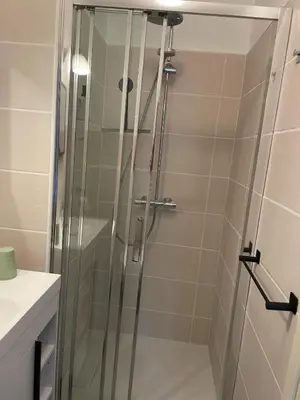 a shower with a glass door in a bathroom at La Cerisaie - Chambres d'hôtes & gites in Riols