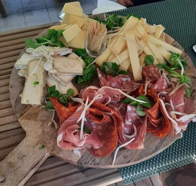 a plate of food with meats and cheese on a table at Domaine La Sauzette in Palaja