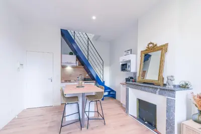 a living room with a table and a fireplace at Romantique Duplex au pied de la cité in Carcassonne
