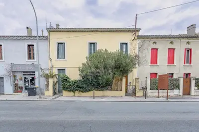 a building with red windows on a city street at Romantique Duplex au pied de la cité in Carcassonne