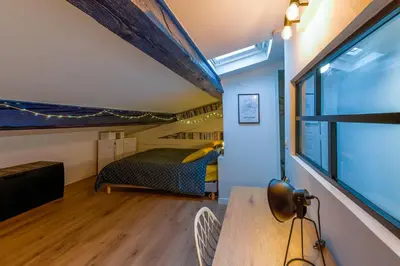 a room with a bed and a table and a window at Romantique Duplex au pied de la cité in Carcassonne