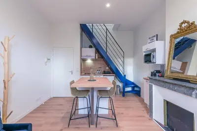 a dining room with a table and a staircase at Romantique Duplex au pied de la cité in Carcassonne