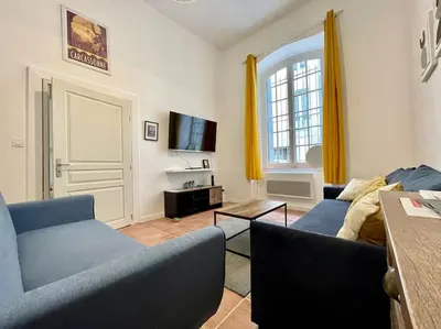 a living room with two blue couches and a tv at Appartement confort - Carcassonne centre in Carcassonne