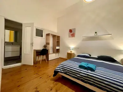 a bedroom with a large bed with blue pillows at Appartement confort - Carcassonne centre in Carcassonne