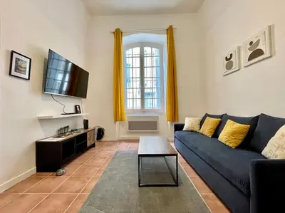 a living room with a blue couch and a tv at Appartement confort - Carcassonne centre in Carcassonne