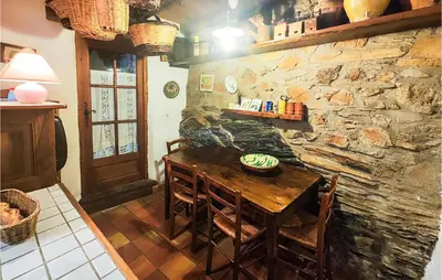 a dining room with a wooden table and a stone wall at Cozy Home In Olargues With Kitchen in Olargues