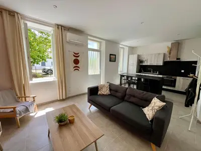 a living room with a couch and a table at Le Riquet - jardin privé, clim, RDC in Castelnaudary