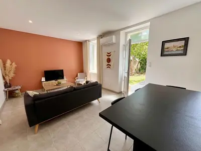 a living room with a couch and a table at Le Riquet - jardin privé, clim, RDC in Castelnaudary