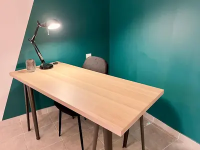 a wooden table with a lamp and a chair at Le Riquet - jardin privé, clim, RDC in Castelnaudary