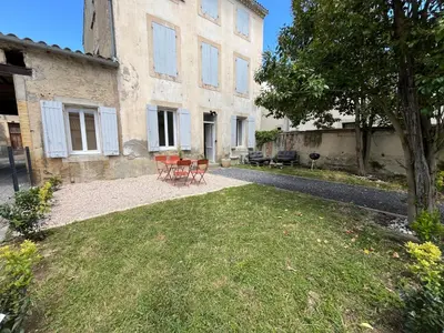 two chairs and a table in front of a building at Le Riquet - jardin privé, clim, RDC in Castelnaudary