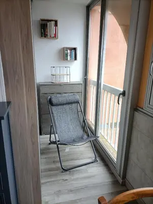 a chair sitting on a balcony next to a window at Le clin d'oeil sur le port. in Gruissan