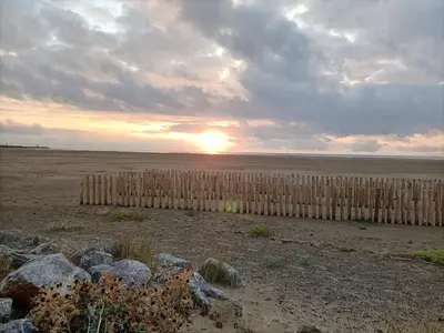 a fence in a field with the sunset in the background at Le clin d'oeil sur le port. in Gruissan