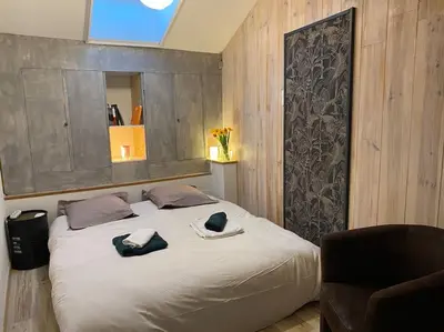 a bedroom with a large bed with blue towels on it at Dupleix au Fil du Canal in Narbonne