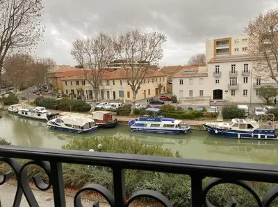 a view of boats in a river from a balcony at Dupleix au Fil du Canal in Narbonne