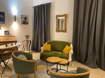 a living room with a green couch and chairs at Dupleix au Fil du Canal in Narbonne