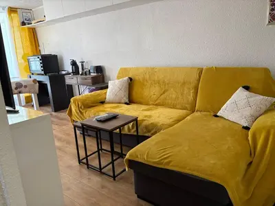 a yellow couch in a living room with a table at Le zéphyr in Gruissan