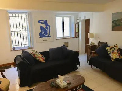 a living room with a black couch and a table at Maison Ventenac village house in Ventenac en Minervois